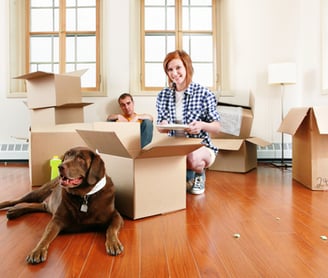 a woman sitting on a couch with a dog in a box