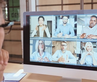 a man in a white shirt and glasses is looking at a computer screen