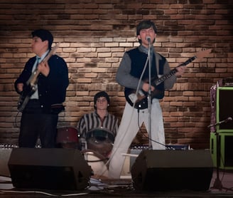 "Los Rockas Surf" a mediados de los. 80's, a group of people standing on stage with guitars