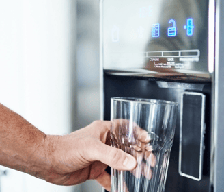 a person holding a glass of wine in front of a machine