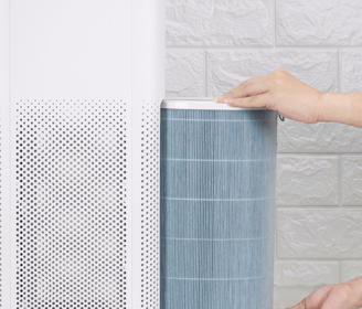 a person holding a blue and white air purifier
