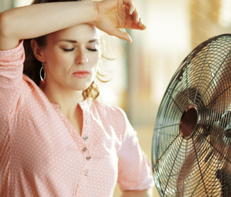 a woman in a pink shirt is holding her hand up to her head