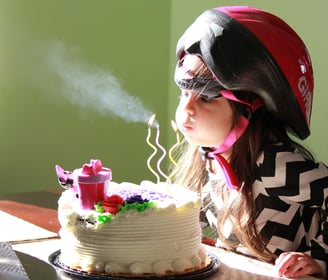 a young girl blowing out birthday candles