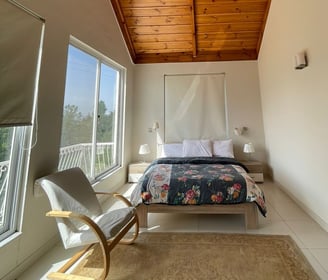 master bedroom with a ceiling fan and revolving chair with natural light coming in