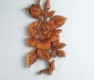 a wooden carved rose flower on a wall
