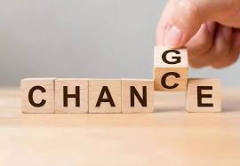 a person holding a wooden block with the word change change