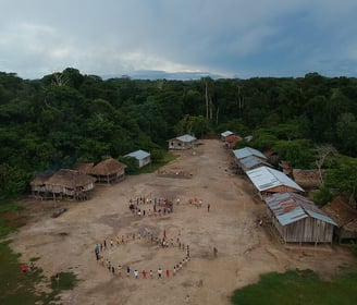 a group of people standing around a group of houses