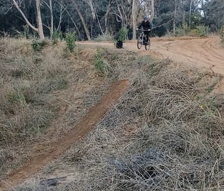 Mountain bike rider dropping into a step-down jump with a lower landing