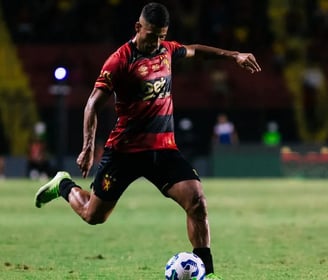 a man in a red shirt is playing soccer