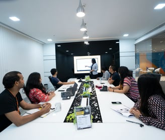 a group of people sitting around a table with a man in a suit and tie
