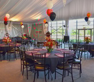 a large room with tables and chairs and balloons and flower decoration
