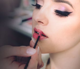 women recieving cosmetic application  of lipstick and facial