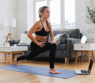 a woman in a black bra top and black leggings is doing yoga