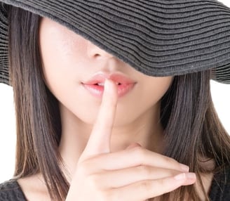 woman with a finger to her mouth
