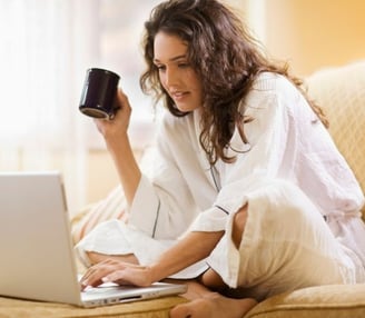 a woman sitting on a couch with a cup of coffee