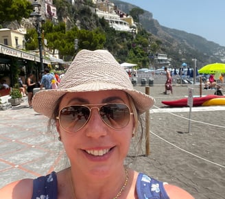 mulher com óculos de sol e chapéu em praia
