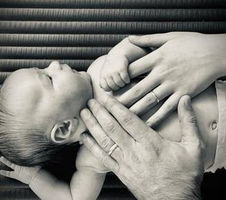 a couple holding hands with their baby