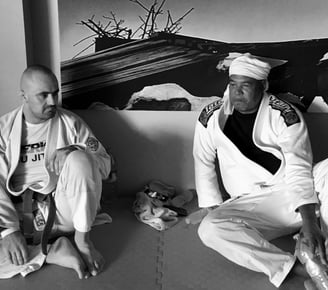 two men sitting on the mat