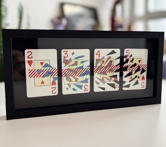 imagem da obra, composta por 4 cartas de baralho com intervenções de washi tape e fita isolante, emolduradas com fundo preto.