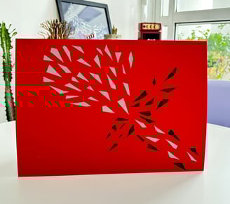 arte em fita isolante prata e preta sobre papel vermelho.