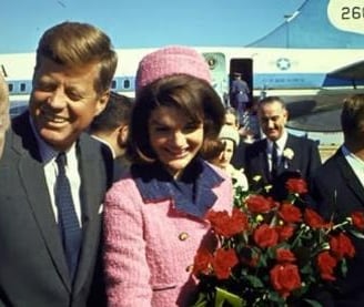 a man and woman standing in front of a plane