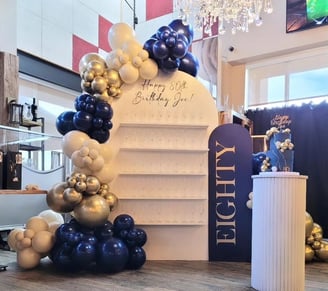 Balloon garland paired with our champagne/treat wall for an 80th birthday
