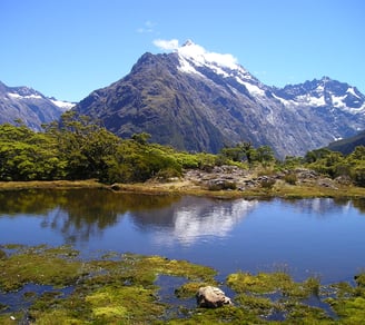 a mountain scene with a lake and mountains in the background