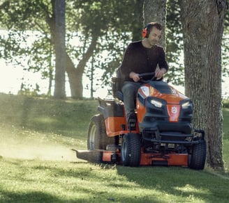 a man riding on a lawn mower with a lawn mower