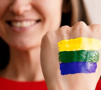 a woman with a rainbow - colored painted on her hand