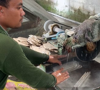 Workers are cutting natural stone to make mosaics