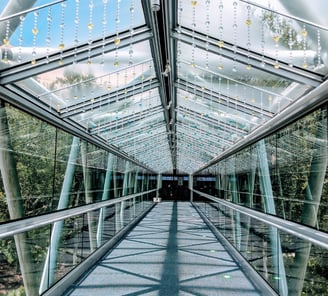 a walkway with a glass walkway and a skylight