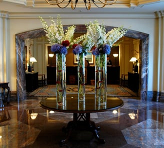 a table with vases and flowers in a hotel lobby
