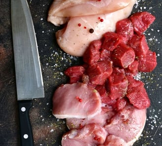 a knife and meat on a cutting board