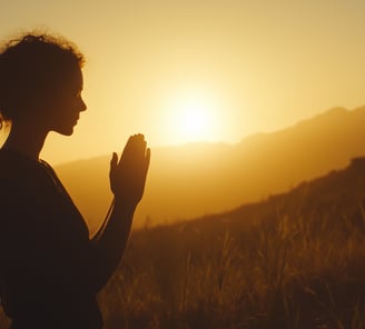 Silhouette of a woman praying at dawn/sunset