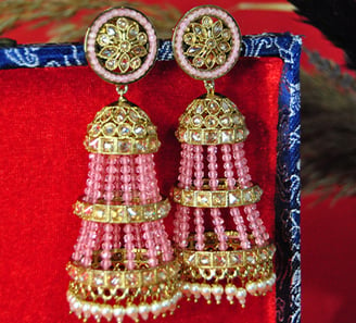 a pair of earrings with pink beads and gold accents