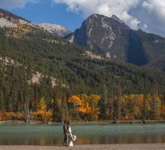 a bride and groom walking by the athabasca river