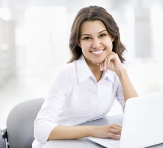 a woman sitting at a table with a laptop