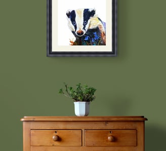 Badger painting in black frame on green wall