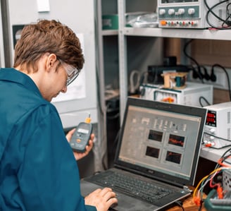 A man standing in front of a computer doing Sound Attenuation Field Testing