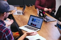 a man sitting at a table with a laptop and a laptop