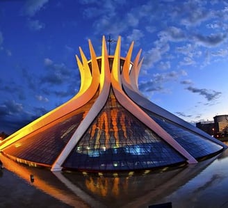 Catedral Metropolitana de Brasília iluminada pelo sol ao final do dia com céu azul ao fundo