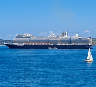 Sail boat on the sea with a cruise ship in the background