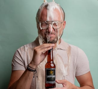 fotografía corporativa gastronómica de un hombre tirándose una cerveza sapporo por la cabeza