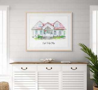 Painting of a cottage hangs above a cabinet