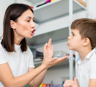 Orthophoniste avec un enfant en séance de rééducation du langage