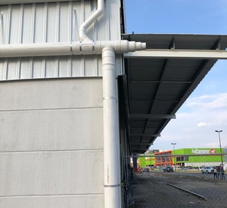 Tuberías aéreas instaladas en el techo de una nave industrial para canalizar agua de lluvia.