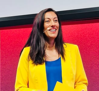 Aurelie Litynski speaking on stage about positive workplace culture