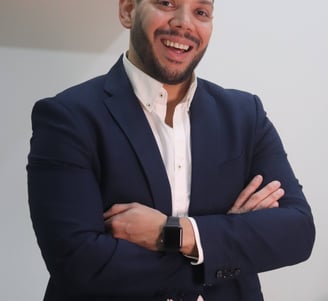 a man in a suit and white shirt smiling