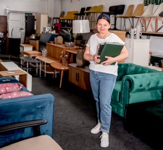 Simona, founder of Exdi Home and Exdi Furniture, standing in her Nottingham showroom surrounded by s