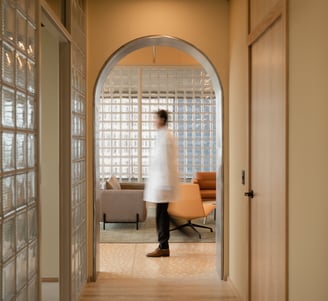 Fertility doctor walking through warm, modern clinic hallway – book a free consultation.
